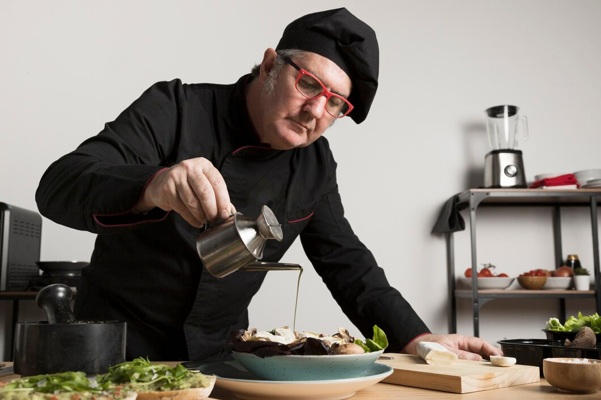 low-angle-chef-seasoning-salad_23-2148471931.jpg