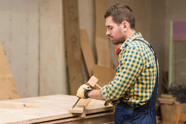 side-view-male-carpenter-carving-wood-with-chisel-workshop_23-2147944945.jpg