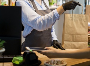 sales-assistant-handing-out-shopping-bag-customer.jpg