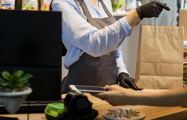 sales-assistant-handing-out-shopping-bag-customer.jpg