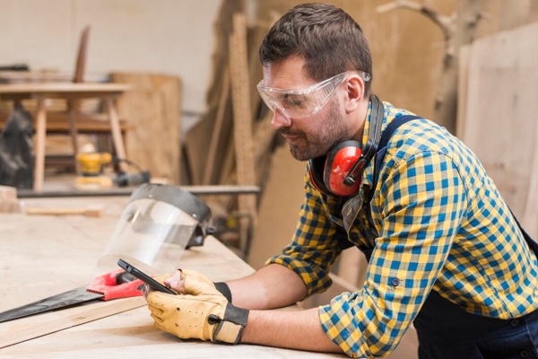 side-view-male-carpenter-using-mobile-phone-workshop_23-2147944901.jpg