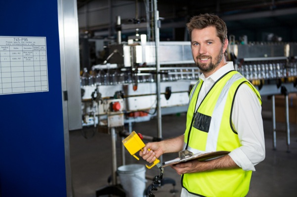 male_worker_using_machinery_at_juice_factory.jpg