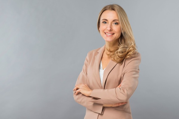 smiling-portrait-confident-blonde-young-woman-standing-against-gray-backdrop_23-2148029031.jpg