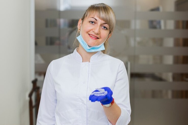 dentist-smiling-holding-invisible-retainers_23-2148380372.jpg