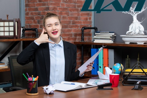 confident-young-lady-sitting-table-holding-document-making-call-me-gesture-office_140725-105909.jpg