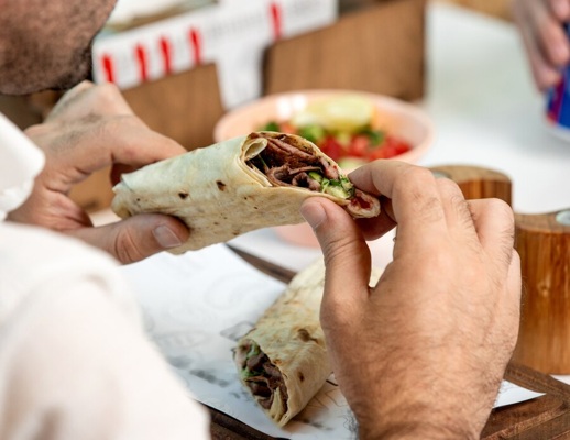 man-holding-beef-burger-wrapped-flatbread_140725-5032.jpg