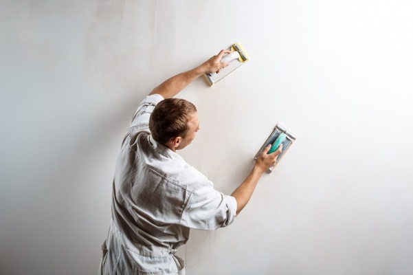 worker-grinding-white-wall-with-sandpaper_176420-4772.jpg