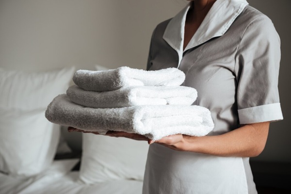 young-hotel-maid-standing-holding-fresh-clean-towels_171337-12687.jpg