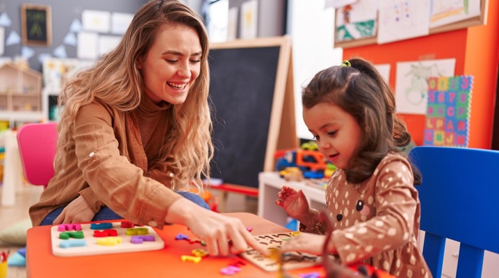 teacher-toddler-playing-with-maths-puzzle-game-sitting-table-kindergarten_839833-6458.jpg