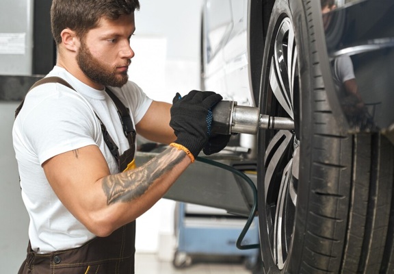 brutal-mechanic-fixing-hubcap-car-wheel_7502-4419.jpg