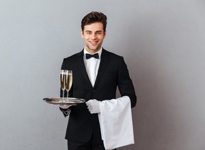 happy-young-waiter-holding-glass-champagne-towel_171337-5290.jpg