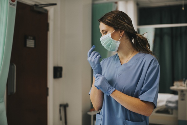 female-nurse-with-mask-putting-gloves.jpg