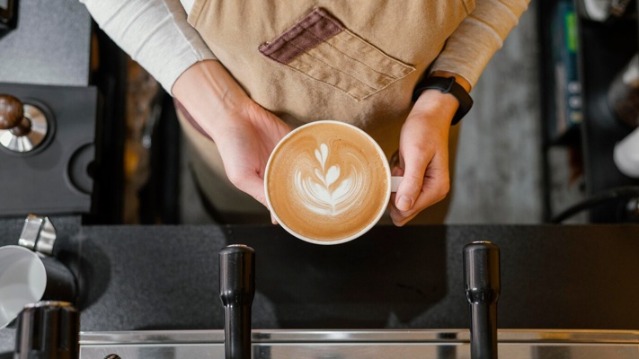 top-view-female-barista-holding-cup-coffee_23-2148824445.jpg