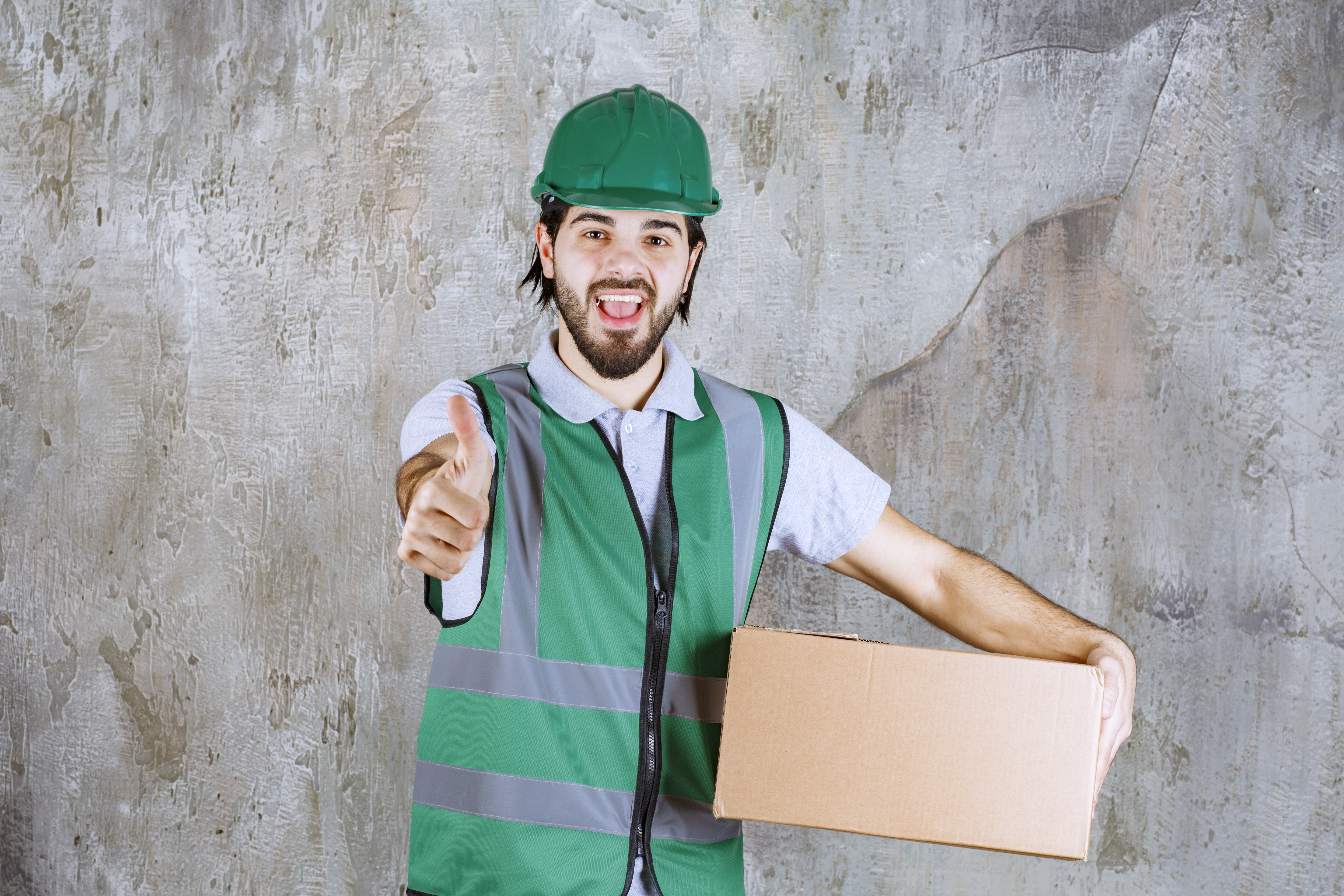 engineer-yellow-gear-helmet-holding-cardboard-box-showing-positive-hand-sign.jpg