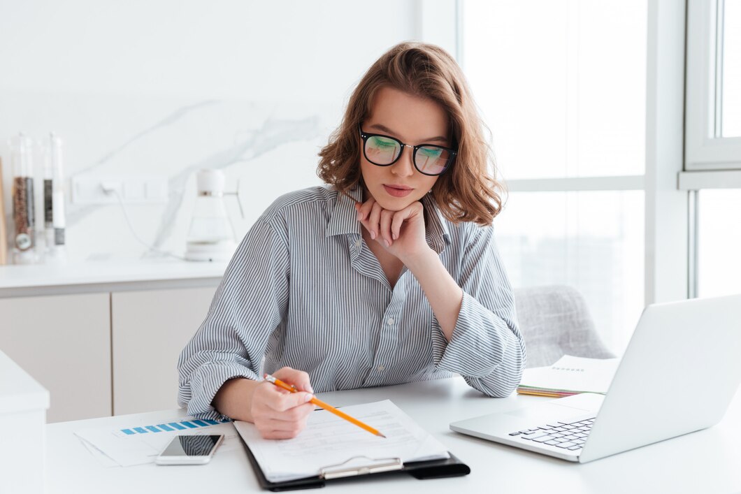 young-concentrated-businesswoman-glasses-striped-shirt-working-with-papers-home_171337-13052.jpg