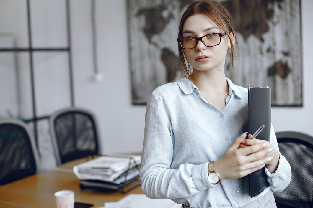 woman-holding-folder-girl-looks-camera-beauty-glasses_1157-40434.jpg